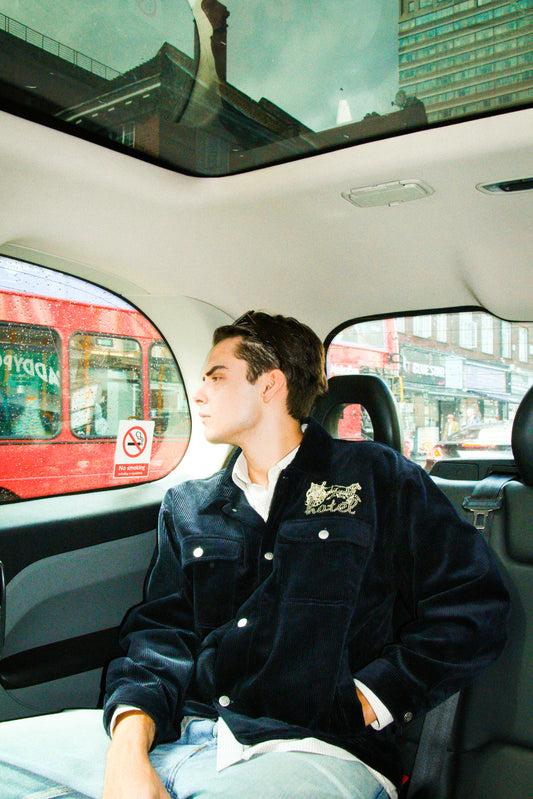 Person sitting in a car with a cityscape visible through the window